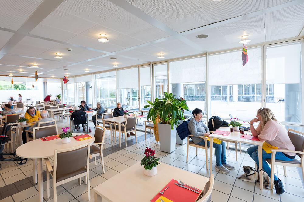 Des personnes en train de manger et de discuter au restaurant de Mon Repos.